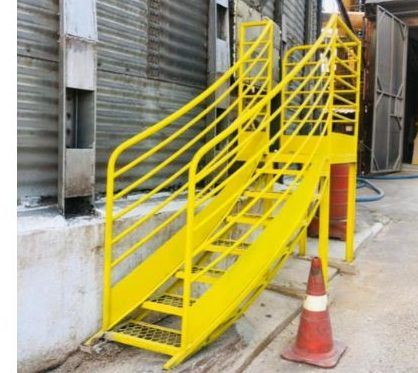 Escada metálica amarela junto a silo