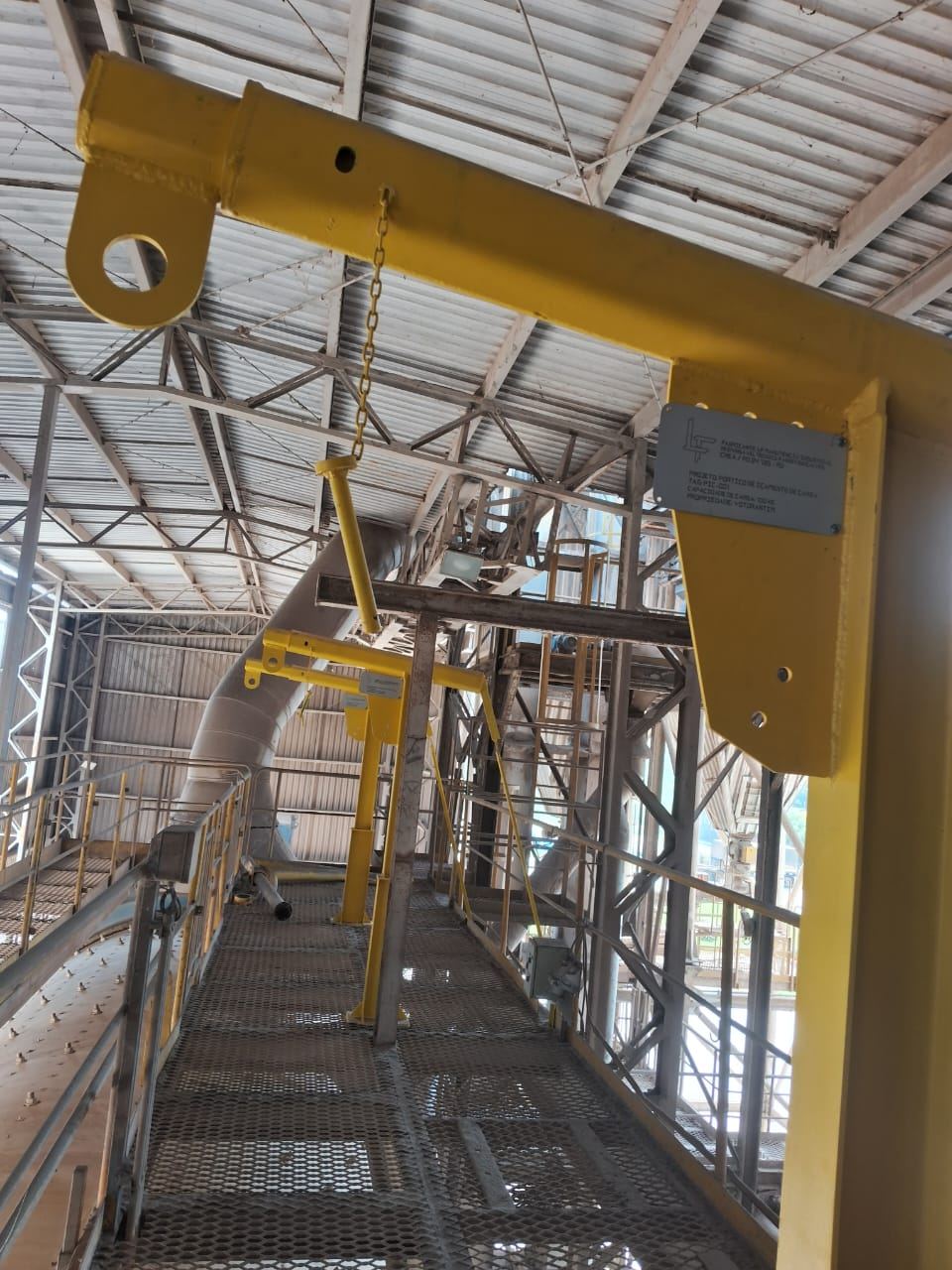 Pórtico amarelo de içamento instalado sobre passarela industrial